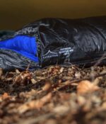 Criterion Quantum 450 sleeping bag in the woods under a tarp with a blue inner and black outer
